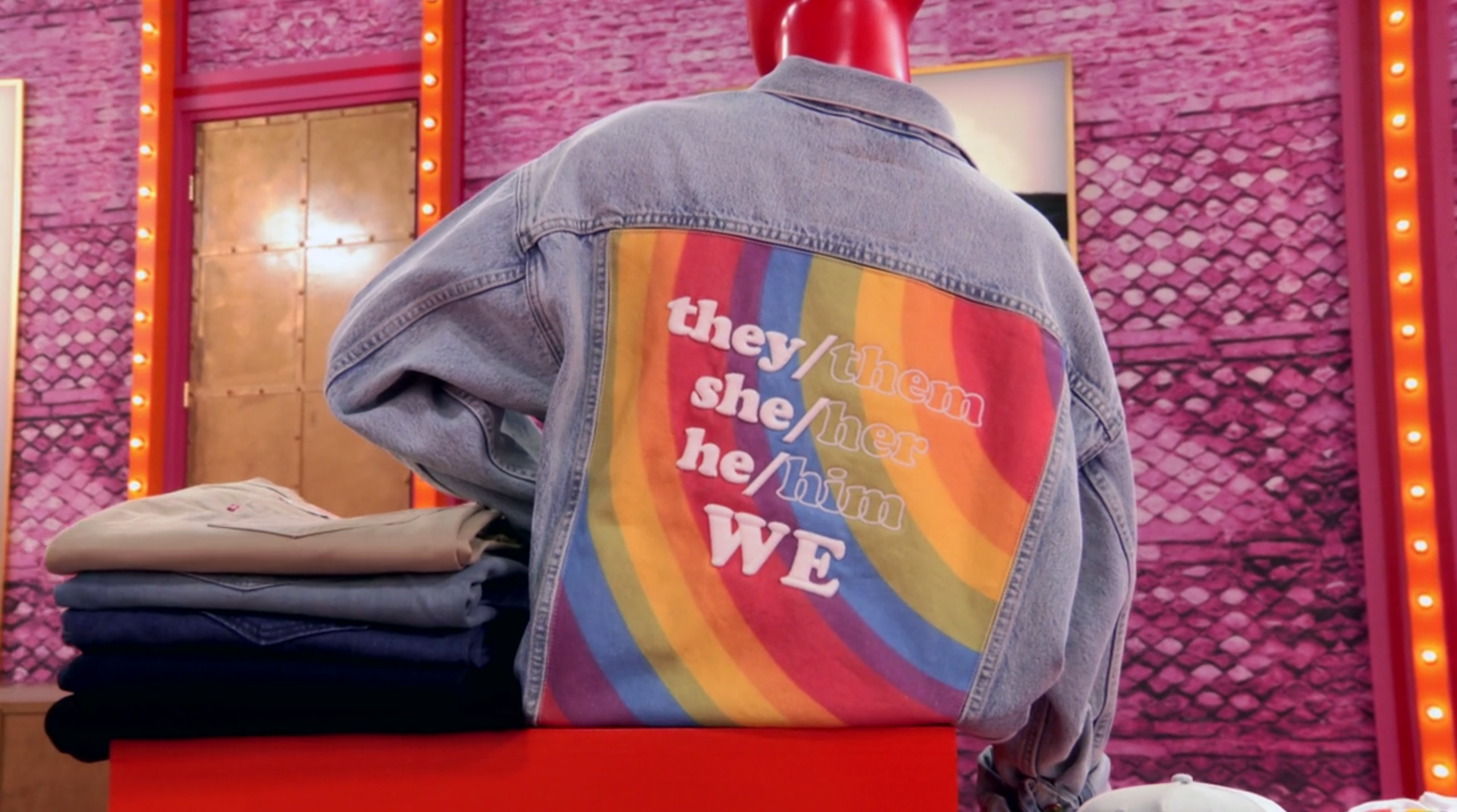 A jacket reading "they/them, she/her, he/him, WE."