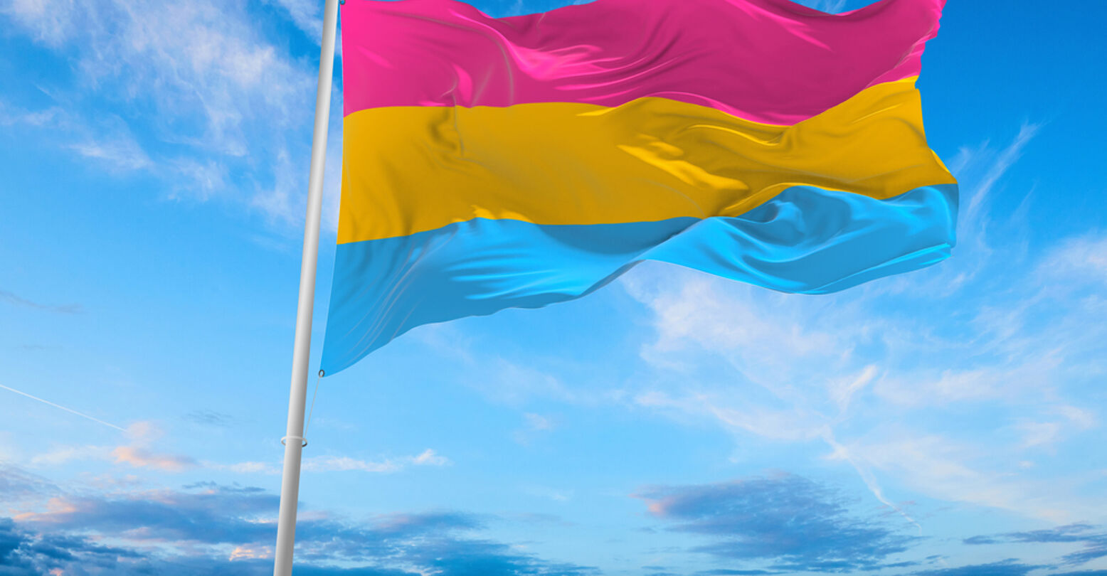 Pansexuality Pride flag waving in the wind on flagpole against the sky