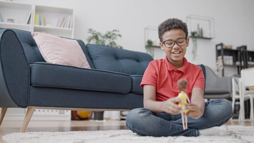 A boy plays with a doll