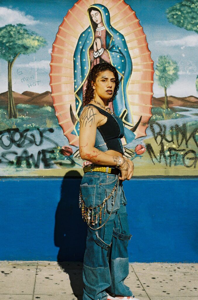 A model poses in front of a Virgin Mary mural wearing designs by Gypsy Sport.